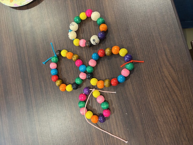 Colorful pony-bead bracelets shaped into letters